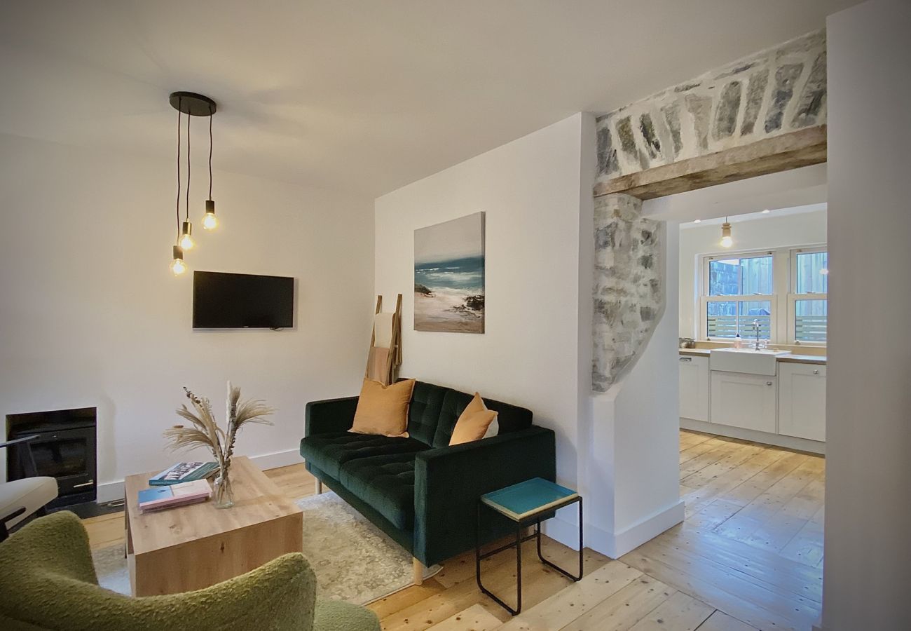 Clifden Town Townhouse. Connemara. Open plan lounge with comfortable sofa, wooden floors, TV.