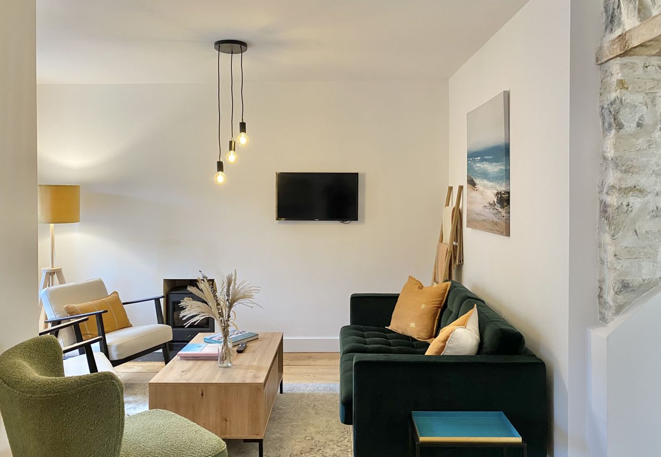 Clifden Town Townhouse. Connemara. Open plan lounge with comfortable sofa, wooden floors, TV. Contemporary lighting, modern furniture.