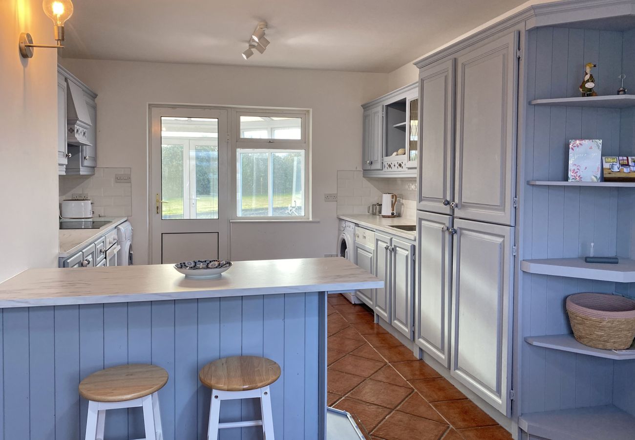 Glynsk Holiday Home. Contemporary fitted kitchen, all appliances. Counter with two stools. 
