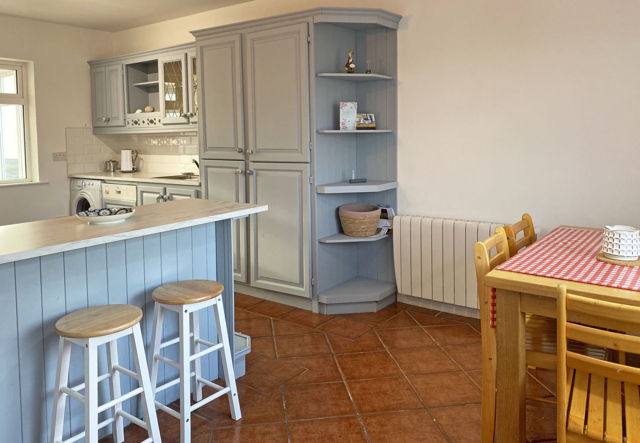 Glynsk Holiday Home. Contemporary fitted kitchen, all appliances. Counter with two stools. Dining table 4 seats. 