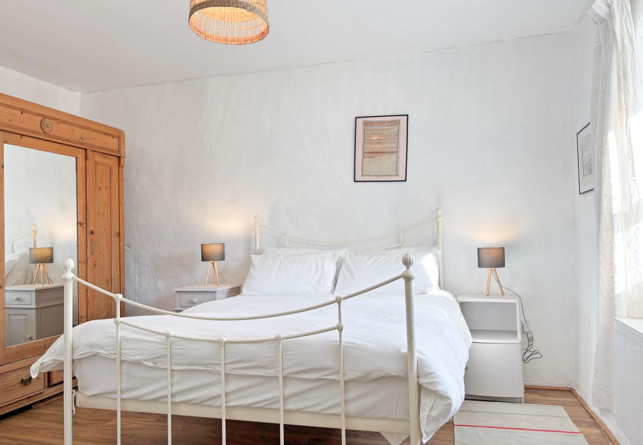 Moyard Stone Cottage, Connemara.  Bedroom, white, clean, wooden flooring, bright window, pine wardrobe. 