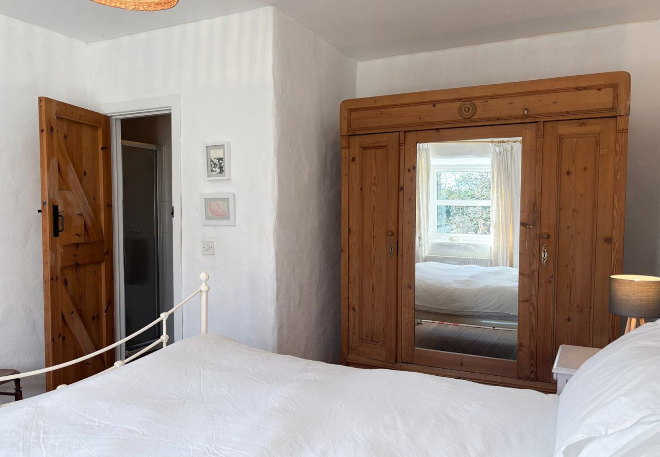 Moyard Stone Cottage, Connemara.  Bedroom, white cottage with wardrobe and wooden floors. 