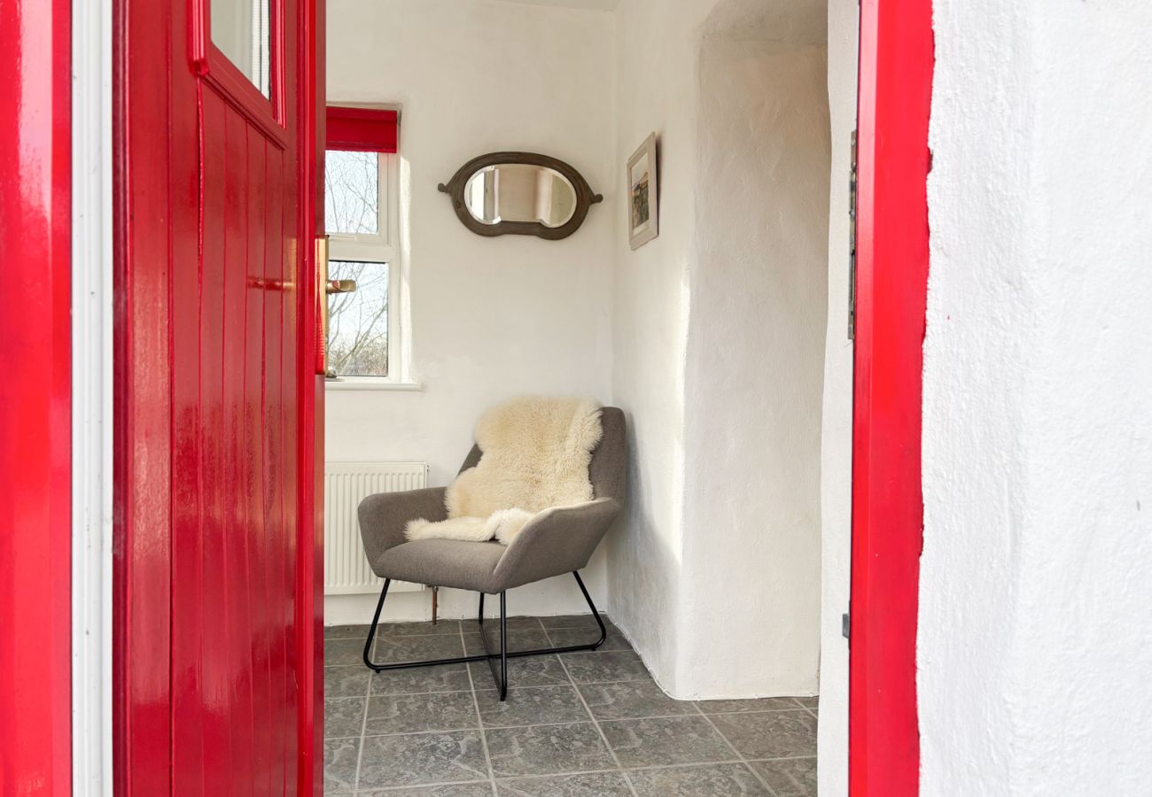 Moyard Stone Cottage, Connemara.  Stone floor, cottage red door, white washed walls. 