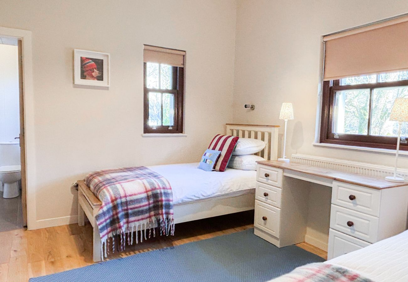 Kylemore Woodland Holiday Cottage, twin beds with window and dresser. 