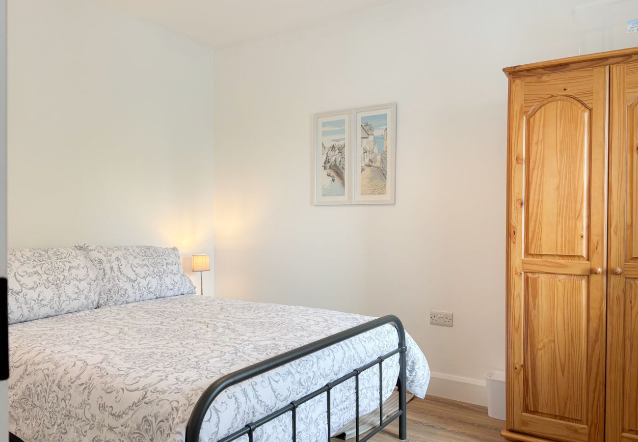 Bluebell Cottage Roundstone. Double bed in bright room with pine wardrobe